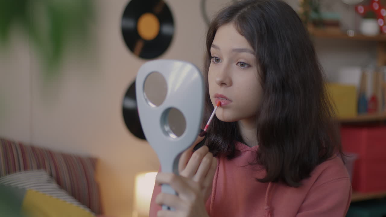 십대 소녀 가 립스틱 을 쓰고 있다