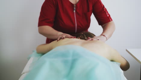 massage therapist does classical procedure with patient back