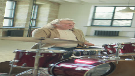 vertical shot of mature man playing drum solo
