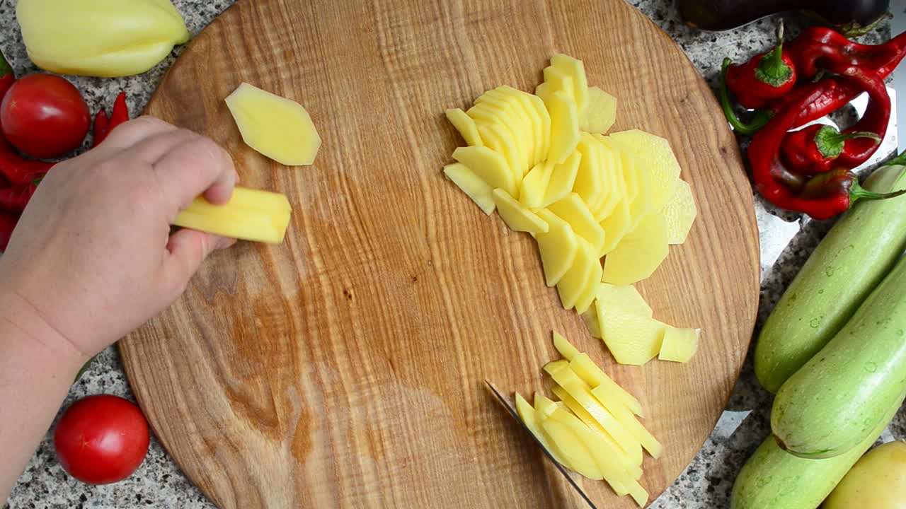 Il cuoco taglia le patate. Preparazione di verdure