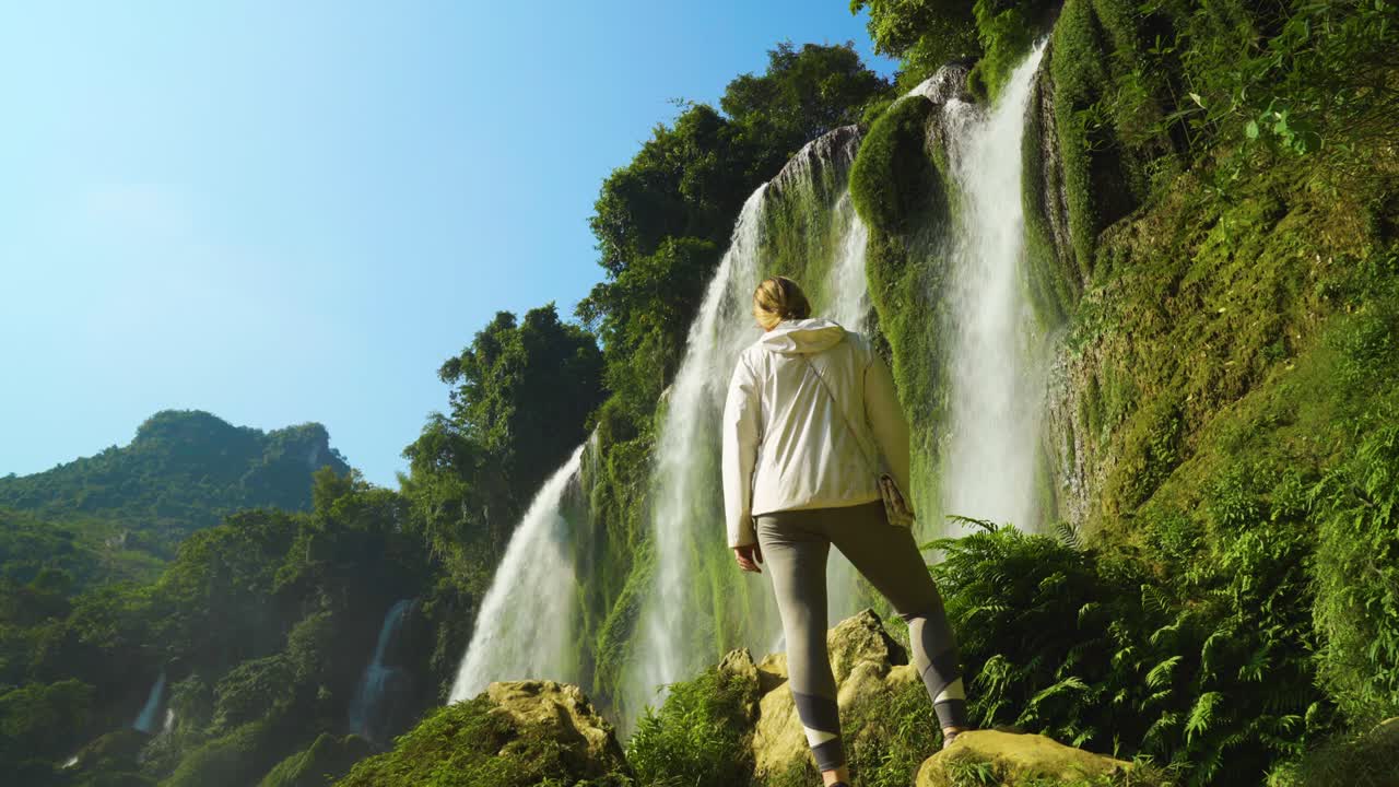 vista trasera de un turista de pie mirando la vista de la cascada ban gioc en cao bang, vietnam