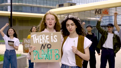 Mujeres-Morenas-Y-Pelirrojas-Sosteniendo-Flores-Y-No-Hay-Pancarta-Del-Planeta-B-En-Una-Manifestación