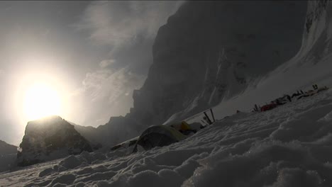 Snow-falling-through-sun-onto-camp