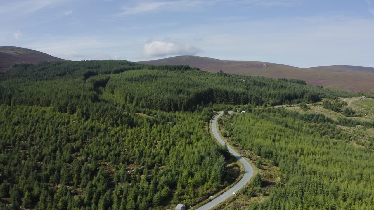vista aérea de una sinuosa carretera de montaña vacía en las montañas de wicklow en un día soleado
