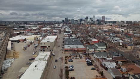 cars drive down one way street in industrial district outskirts of denver colorado on overcast day, panoramic orbit