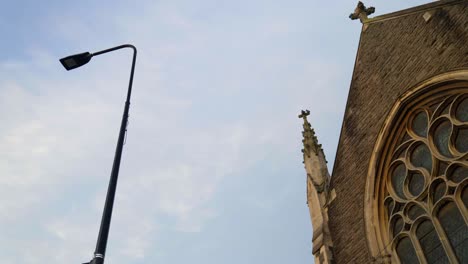 low-angle shot of pigeons flying around a church and lamppost in cardiff