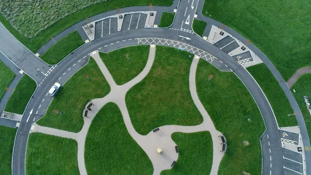 Circular design aerial view above ornamental pathway cemetery garden with parking around outside