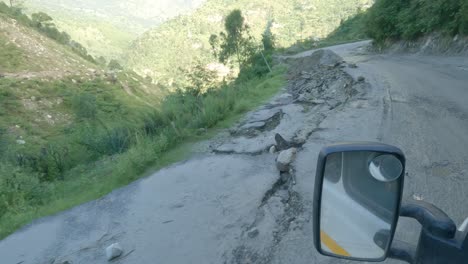 a point-of-view shot of a vehicle riding through a damaged road by recent landslides on the foothills of the indian himalayas in himachal pradesh