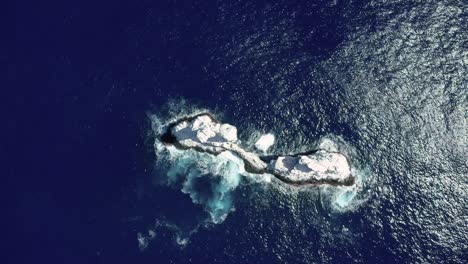 top down aerial view of white guano roca partida islet in azure mexican pacific