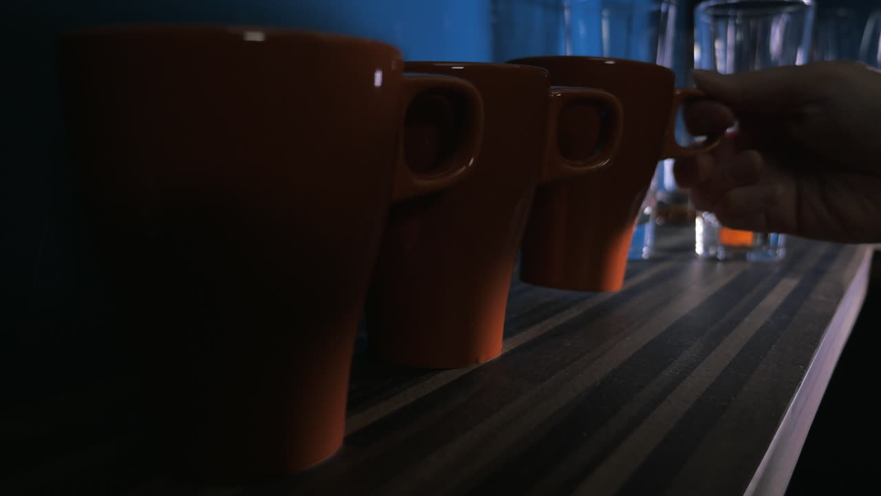 Placing tea cups on the shelf in kitchen
