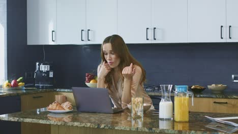 mujer de negocios hablando en la computadora en la cocina. sonrisa de primer plano dama teniendo una charla