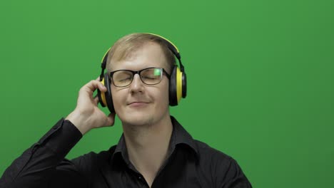 guy listens to music in wireless yellow headphones and dances. chroma key