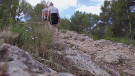 Two-young-women-hiking-on-a-rocky-mountain-path,Alcoi,Valencia,Spain