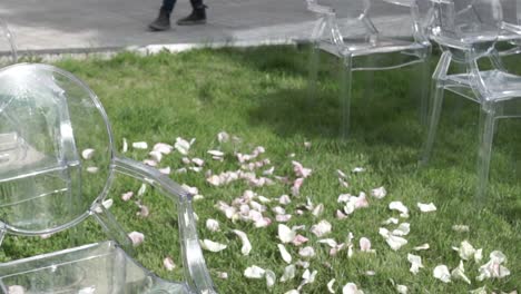 clear plastic chairs in a garden for an outdoor ceremony