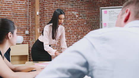 Young-Businesswoman-Standing-And-Leading-Office-Meeting-Around-Table