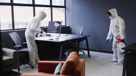 cleaners wearing protective clothes sanitizing modern office space