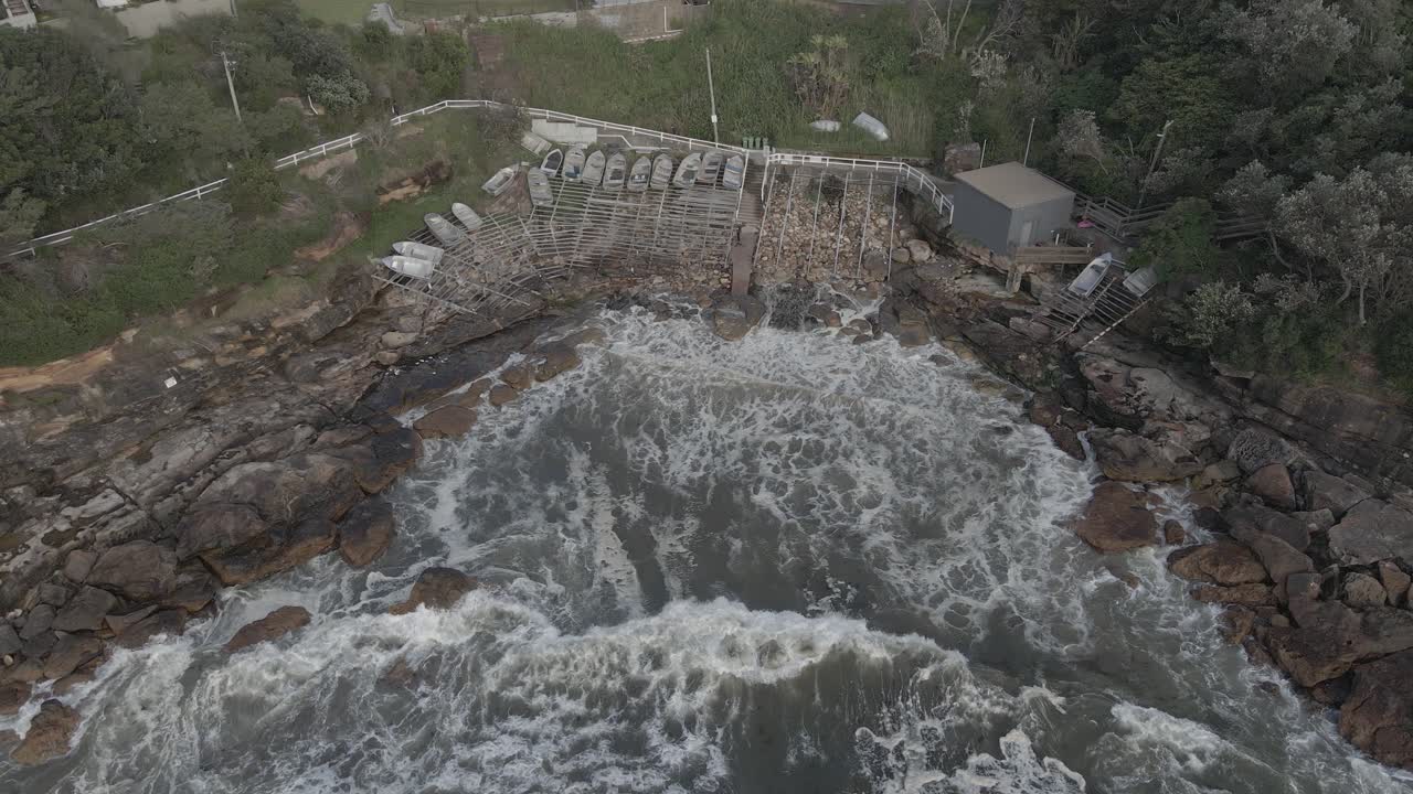 Waves Splashing At Gordon's Bay - Small Boats On The Shore In Coogee, New South Wales - aerial drone, pullback