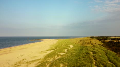 drone flying over beautiful sand dunes and sea on a sunny beach, uk