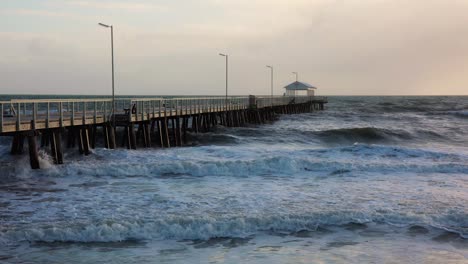 waves crashing into jetty, pier in slow motion