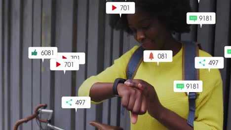 Animation-Von-Social-Media-Symbolen-über-Einer-Afroamerikanischen-Frau,-Die-Auf-Der-Straße-Eine-Smartwatch-Benutzt