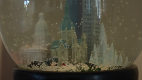 a close-up of a model of saint paul's cathedral, minnesota in a snow globe with flakes falling