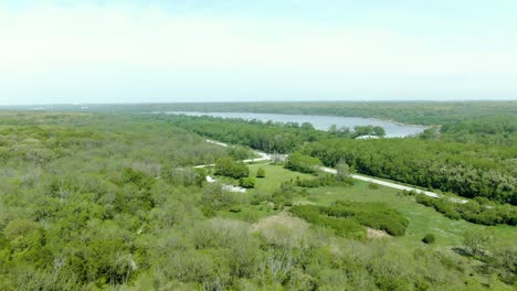 Toma-Aérea-De-Un-Bosque-Con-Un-Lago-En-La-Distancia