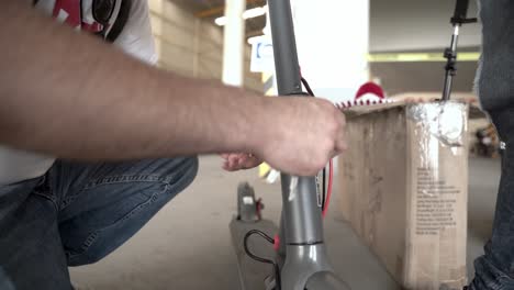 Person-working-on-an-electric-scooter-at-the-shop