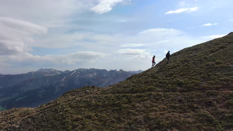 hiking to top of steep hillside with majestic landscape view, aerial side fly