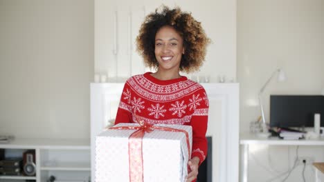 happy smiling girl with afro haircut holding gift