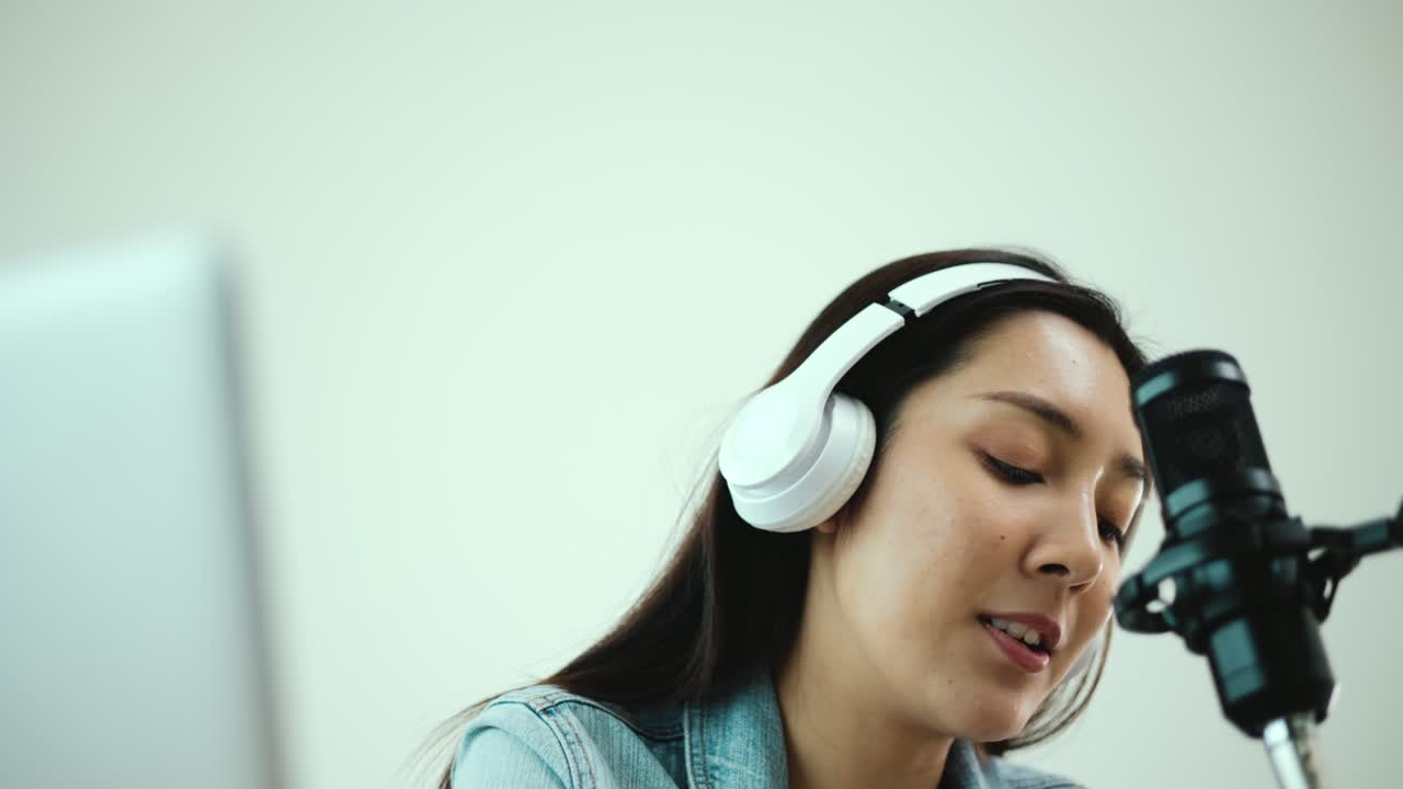 creadora de contenido mujer anfitriona transmitiendo su podcast en portátil con auriculares y micrófono entrevista animando conversación de invitados en el estudio de transmisión.