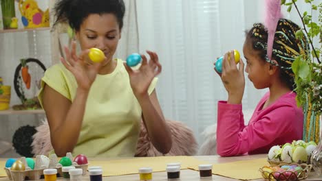 madre e hija pintando huevos de pascua
