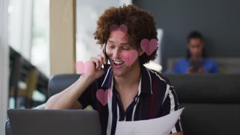 Animación-De-Corazones-Rojos-Sobre-Un-Hombre-De-Negocios-Birracial-Usando-Un-Teléfono-Inteligente