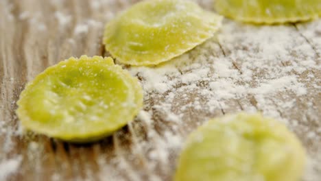 Close-up-of-homemade-pasta-with-flour-on-wooden-background