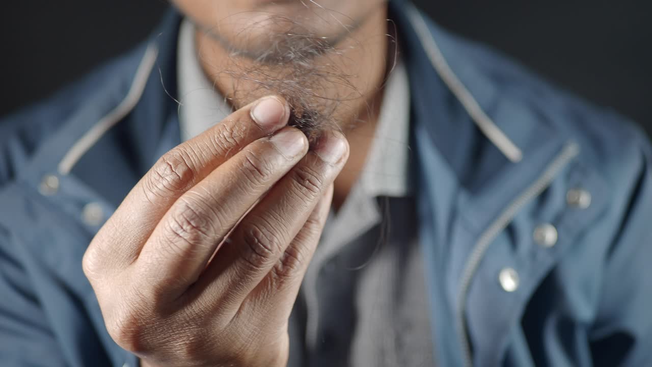 머리카락 한 조각을 들고 있는 남자