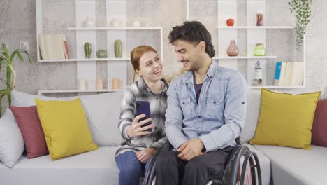 El-Joven-Discapacitado-Y-Su-Novia-Miran-Juntos-El-Teléfono.