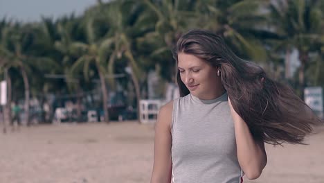 Junge-Frau-Posiert-Am-Strand-Vor-Palmen-In-Zeitlupe