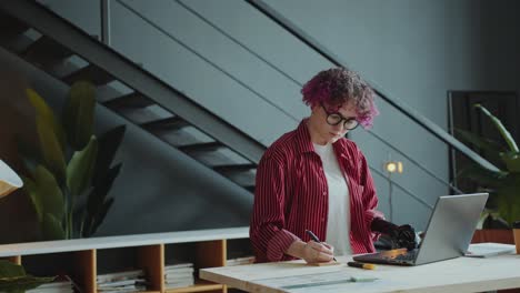 young businesswoman with prosthetic arm working on laptop in office