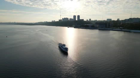boat cruising on a river with a city skyline at sunrise or sunset