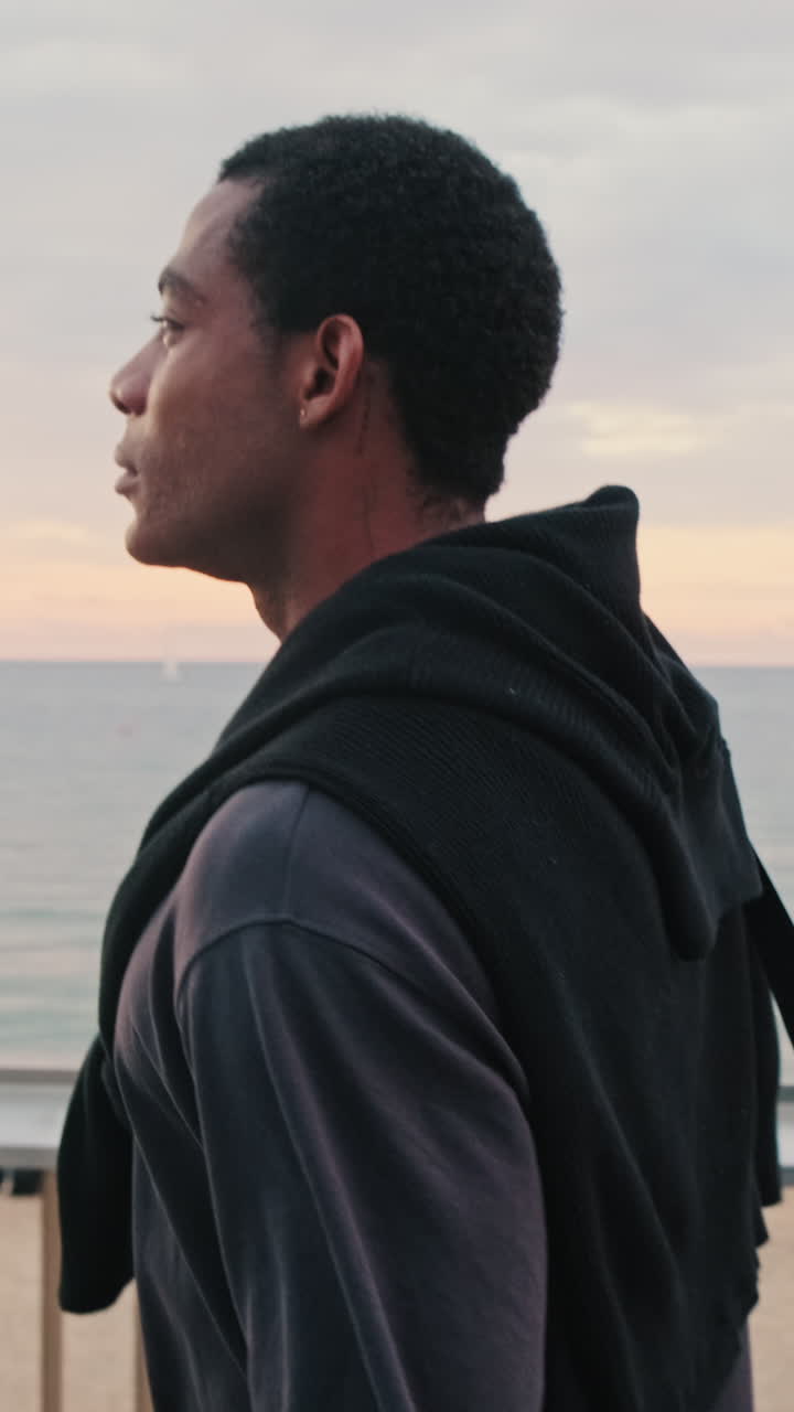 Young Man Looking Out at the Sea During Sunset