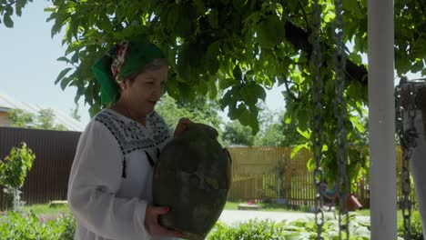 Mujer-Rumana-Llevando-Una-Jarra-De-Agua-Cerca-Del-Pozo---Cerrar