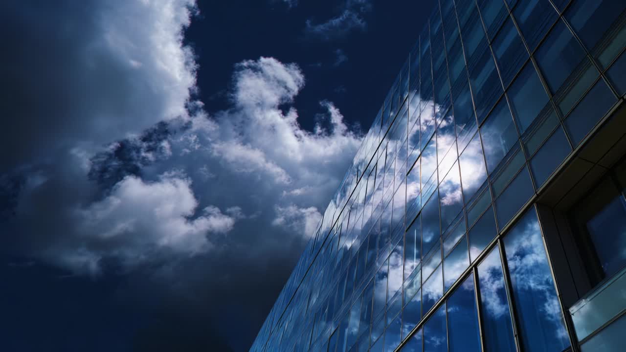 A stunning view of a modern glass building reflecting the dark, moody clouds above, capturing the interplay of light and shadow on its surface, showcasing architectural brilliance in an atmospheric setting