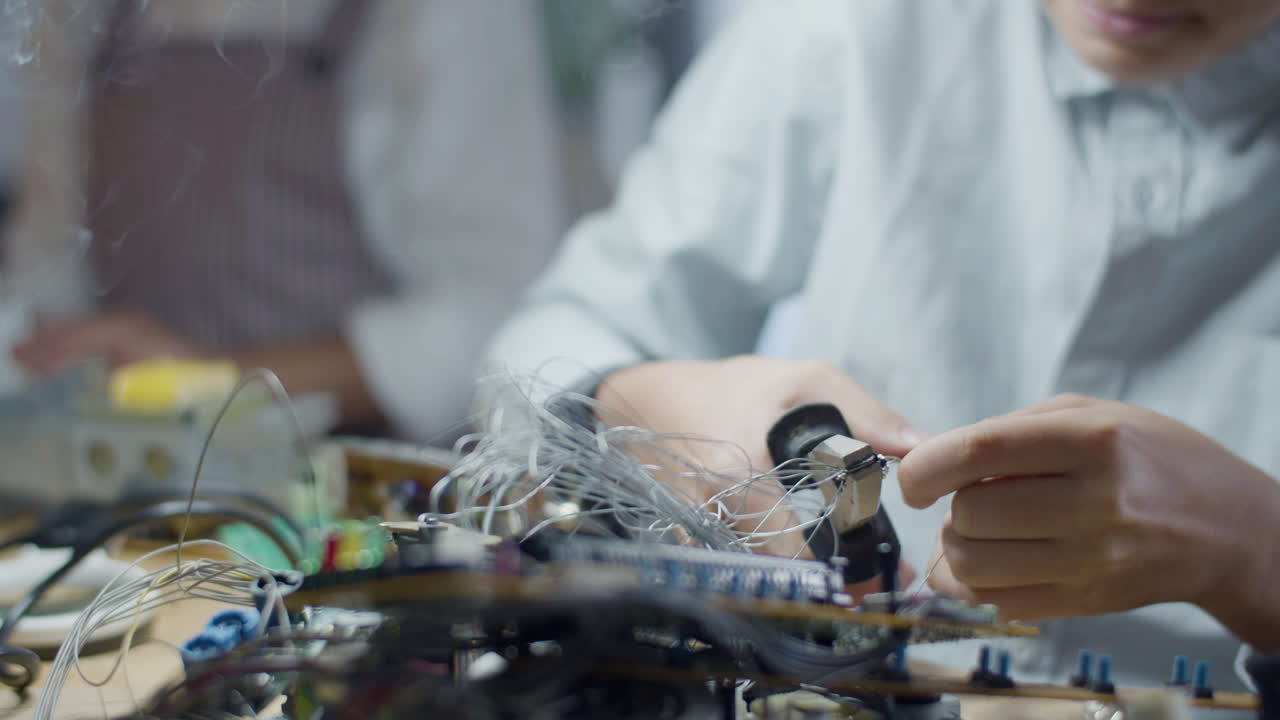 Close up shot of schoolboy pressing tin solder wire with pliers