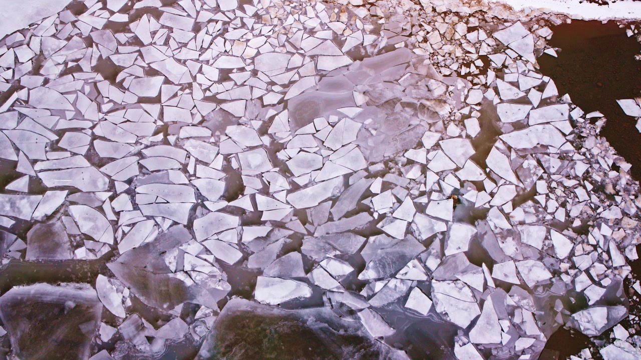 Metraje de dron cenital de hermosos patrones de hielo congelado en los Grandes Lagos en un tranquilo entorno invernal.