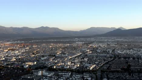 Antena:-Ciudad-De-Lijiang-En-Yunnan-China,-Vista-Del-Paisaje-Urbano-Al-Atardecer