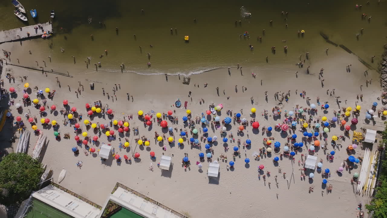 imágenes aéreas que descienden lentamente de la playa roja, praia vermelha, con los que van a la playa y los nadadores en un día caluroso en río de janeiro