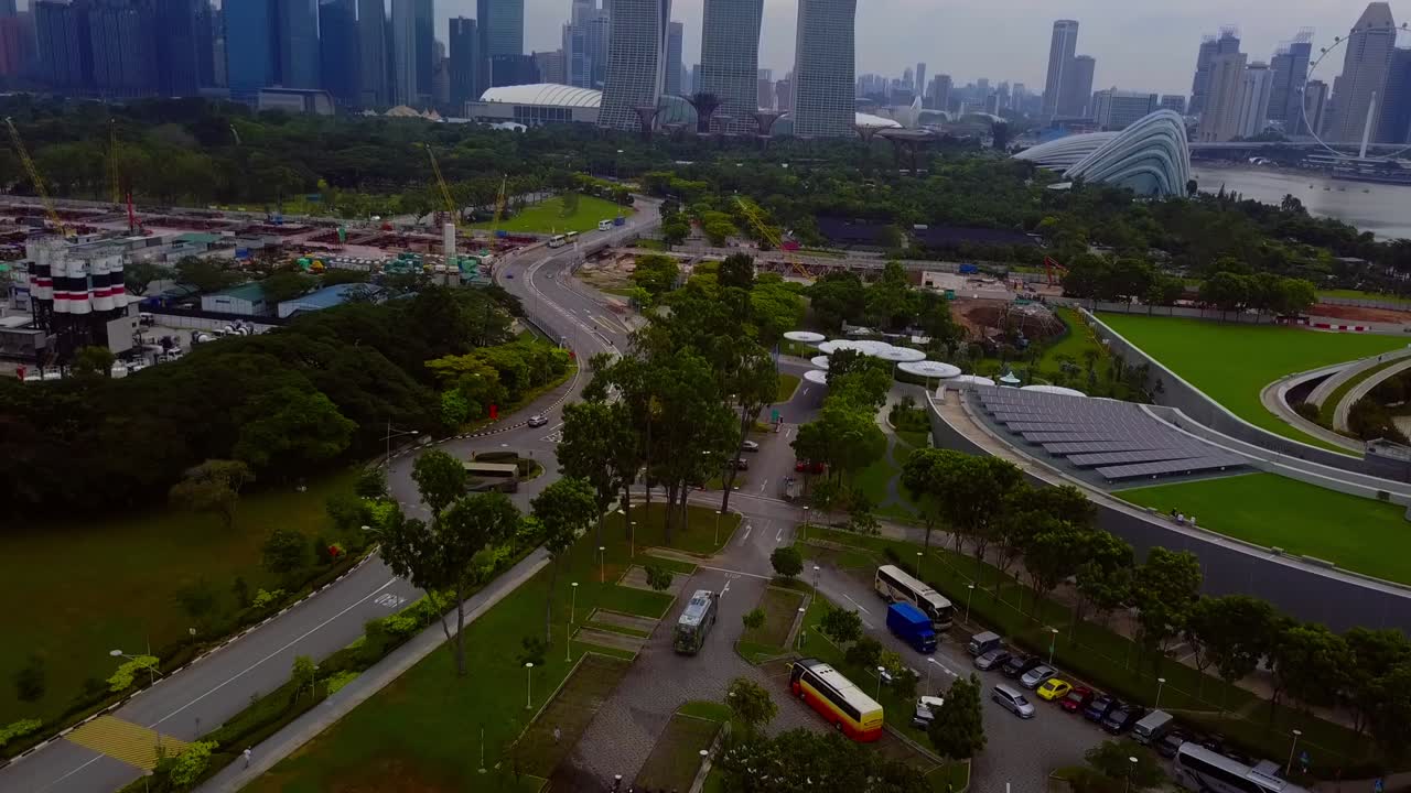 Aerial drone shot tilting up, revealing Marina Bay Sands, Flower Dome, Gardens by the Bay, and the futuristic cityscape of Singapore