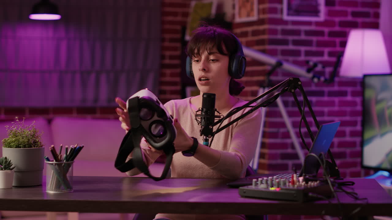 Vlogger recording funny vlog doing virtual reality headset review in home recording studio with professional microphone