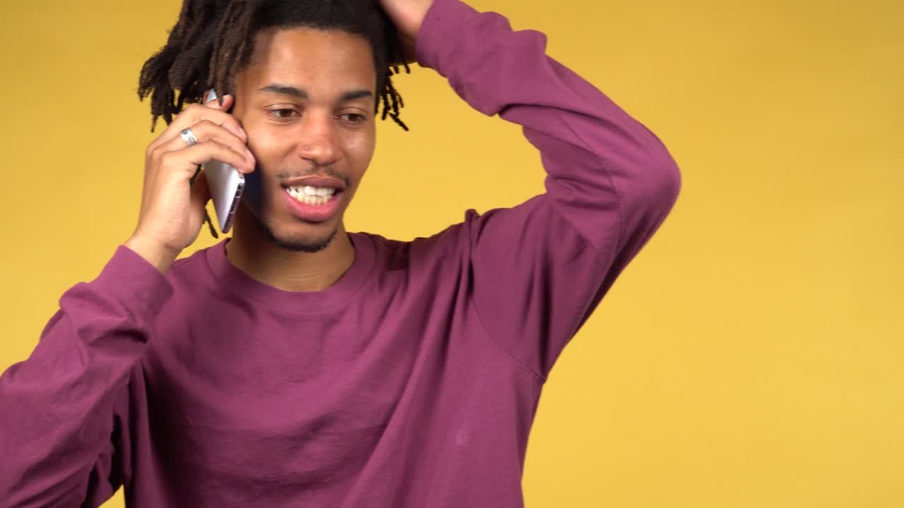Un bello studente di colore era confuso dalle notizie mentre parlava al telefono.