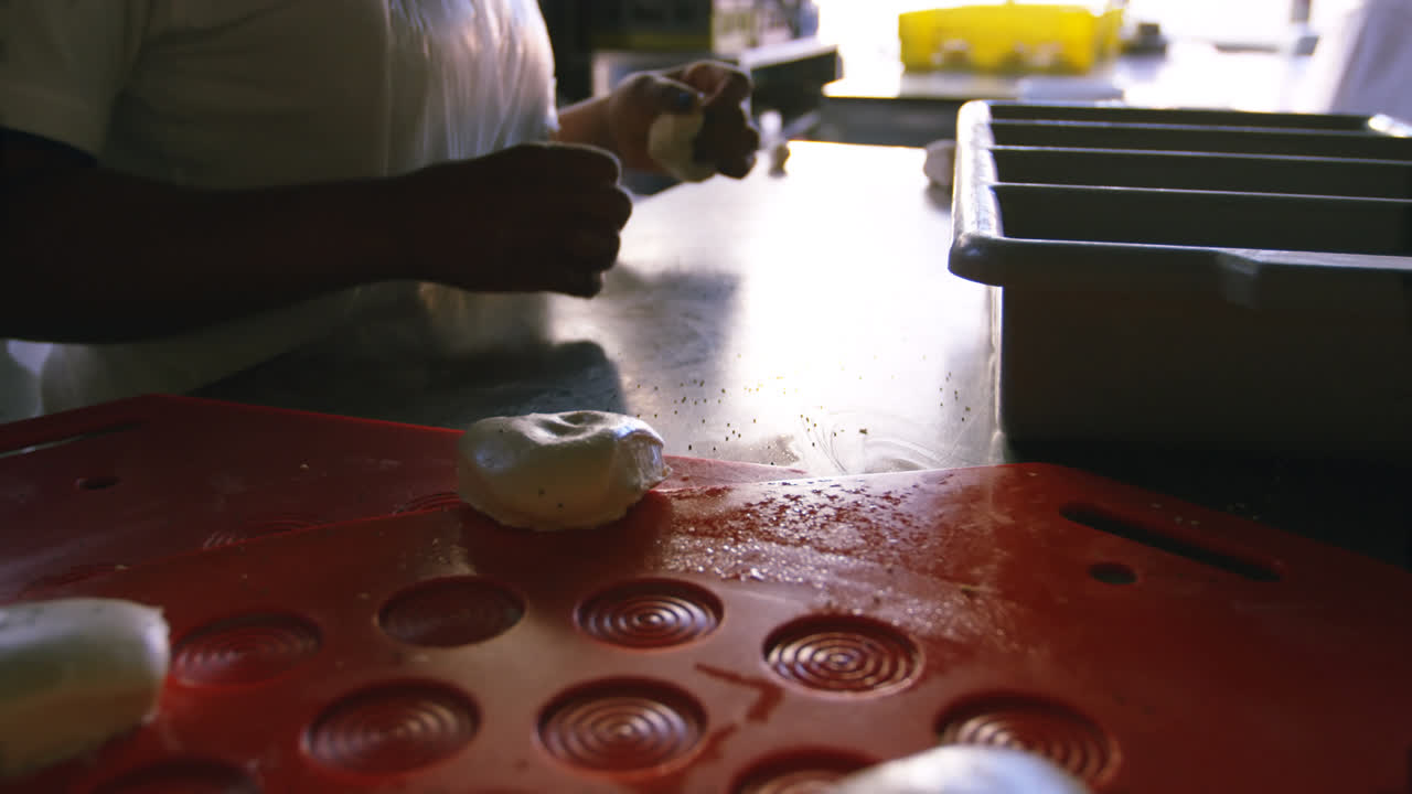 Chef kneading dough on worktop 4k