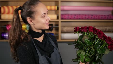 Perfect-bouquet-of-red-roses-from-professional-florist:-young-attractive-female-florist-holding-a-bouquet-of-beautiful-red-roses